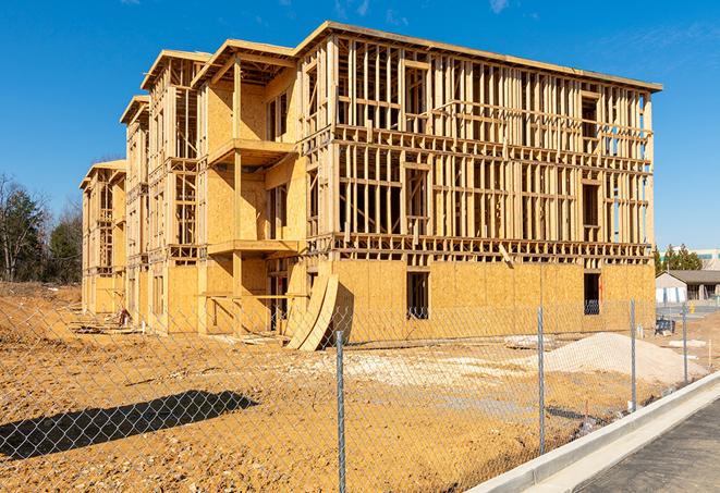 a temporary chain link fence in front of a building under construction, ensuring public safety in Rochert, MN